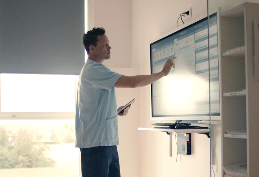 Nurse is working in INSIGHT the patient flow management solution on touchscreens