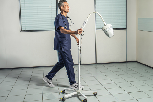 Doctor walking with a Maquet Lucea examination light