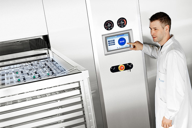 Men sterilizing seringues in Getinge GEV Sterilizer Men sterilizing seringues in Getinge GEV Sterilizer