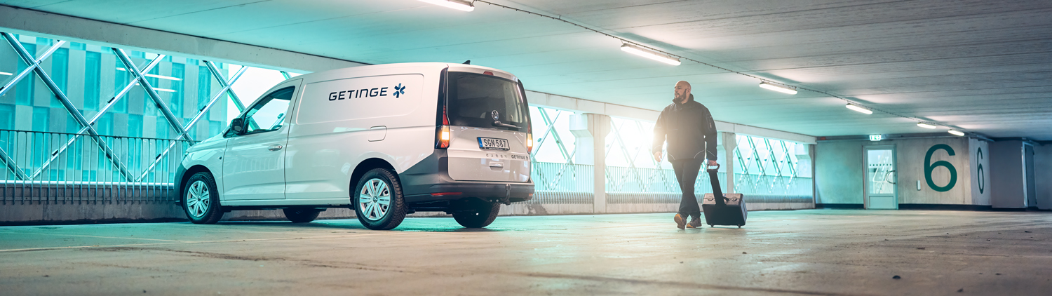 Getinge service car and technician in parking garage